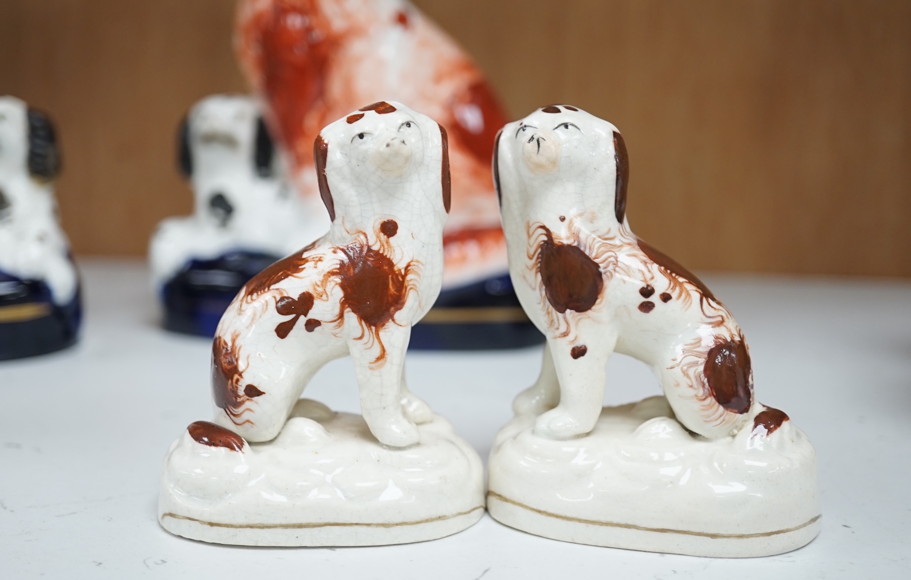 A pair of mid 19th century Staffordshire spaniel and puppy groups, a pair of smaller Staffordshire spaniel figures, and a pair of Staffordshire porcelain figures of standing terriers, c.1835, together with a Continental